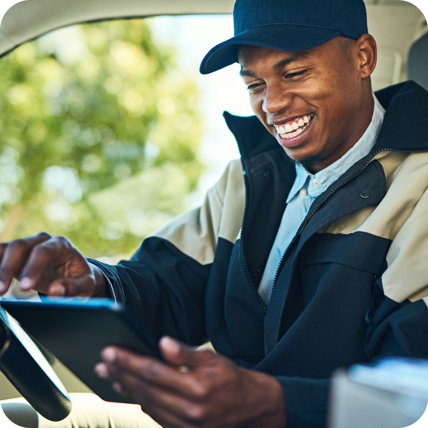 A man smiling at a tablet 